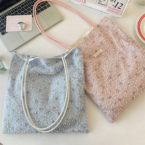 Detail of floral tote bags with pearl mesh overlay in pastel blue and pink colors