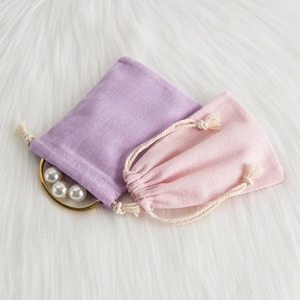 Detail of pink and purple drawstring jewelry pouches with cotton linen fabric texture