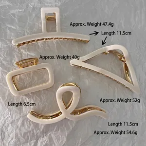 French cream-colored resin shark hair clips set with gold-tone metal springs
