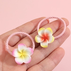 Elastic kids hair ties with plumeria flower charms held in palm against pink background