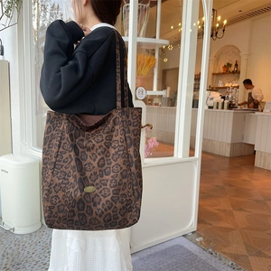 Close-up of a large leopard print tote bag worn over the shoulder for stylish commuting