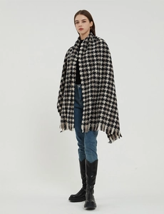 Detail of oversized houndstooth scarf with classic black and white pattern and fringe