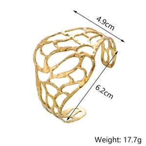 Détail d'un bracelet jonc en acier doré avec motif ajouré et dimensions de 6,2 cm de large