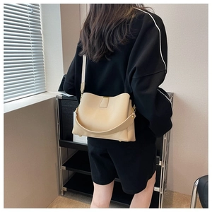 Beige pebbled leather bucket bag shown from behind on a model for casual styling