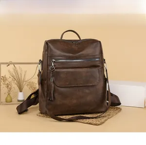 Detail of vintage brown PU leather backpack featuring tassel zippers and adjustable straps