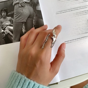 Detailed view of 925 sterling silver liquid metal flame ring on an art book background