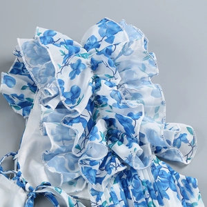 Detail of blue floral chiffon dress with elegant ruffles and fine pleated texture
