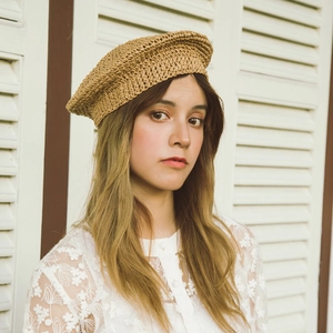 Vintage brown hand-woven straw beret for women shown on model in natural light