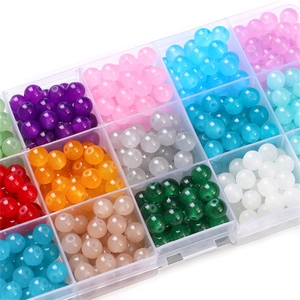 Assorted colorful glass jade beads in a clear organizer box for DIY jewelry making