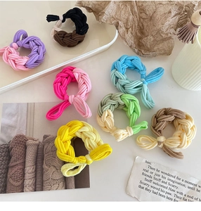 Close-up of colorful braided elastic hair ties in various double-color bow styles