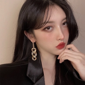 Close-up of elegant gold chain drop earrings worn by a model for a vintage look