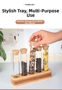 Detailed view of glass storage tubes on a bamboo base holding coffee beans and grains