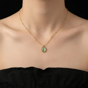 Elegant gold bead necklace with oval light green cat eye stone pendant on model neck