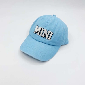 Detailed view of light blue cotton baseball cap with white fuzzy MINI letter embroidery