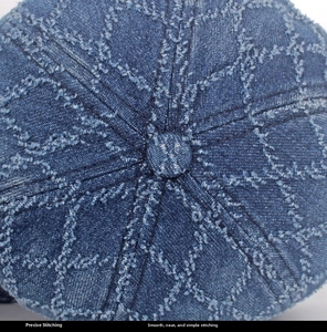 Gros plan d'une casquette en jean bleu délavé avec surpiqûres en losanges et bouton supérieur