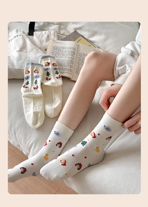 Gros plan de chaussettes crème avec motifs de fille de dessin animé et de sapin