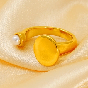 Detail of gold-plated geometric ring with white pearl on premium silk background
