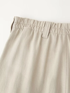 Detailed view of beige casual trousers waistband featuring elastic band and belt loops