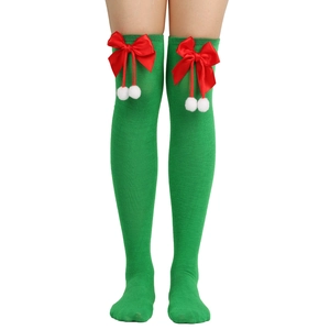 Detail of green Christmas over-the-knee socks with red satin bows and white fuzzy balls