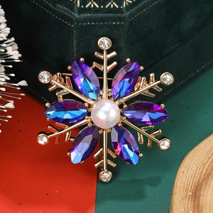Detailed macro view of crystal snowflake brooch with a center pearl and blue gradients