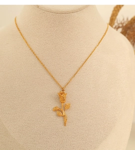 Detailed view of a golden rose flower pendant necklace displayed on a mannequin neck model