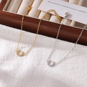 U-shaped horseshoe charm bracelet in gold and silver finish with sparkling cubic zirconia