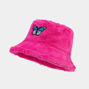 Detail of rose red faux fur bucket hat with embroidered butterfly patch for winter