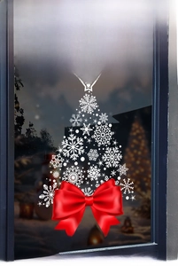 Christmas tree window sticker with white snowflakes and red bow on glass shopfront
