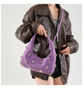 Detail of purple suede hobo bag featuring large silver spherical metal rivets
