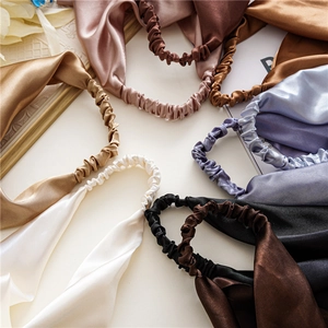 Close-up of smooth satin hair bands in various elegant colors with silk texture