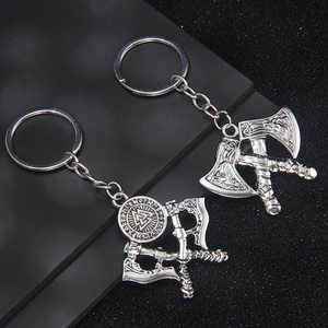 Viking axe keychains featuring engraved dragon motifs and Nordic symbols on dark background