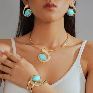 Golden bohemian jewelry set featuring resin oval pendants on collar necklace and cuff bracelet