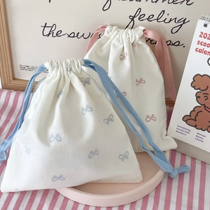 Detailed view of drawstring pouch with sweet pink and blue bow prints on canvas fabric