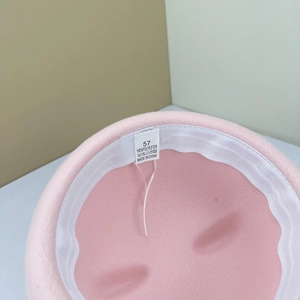 Nahaufnahme des rosa Matrosenhuts mit Etikett für Größe 57 und 100% Polyester