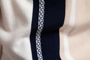 Macro shot of striped knit polo fabric showing detailed navy and beige stitching