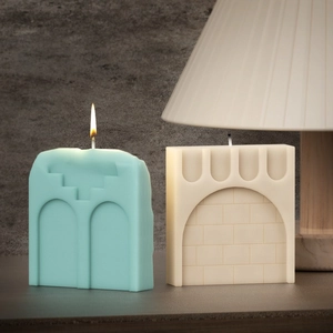 Detailed view of mint green and ivory architectural soy candles with geometric arch designs