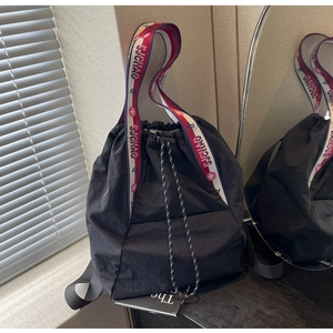 Detalle del bolso negro con cordón, correas tejidas SJCHAO y textura de nailon fuerte