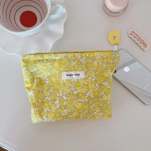 Dettaglio della trousse in cotone floreale con etichetta simple wish e cerniera