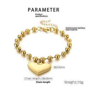 Detailed macro view of gold-plated stainless steel ball chain bracelet with heart charm