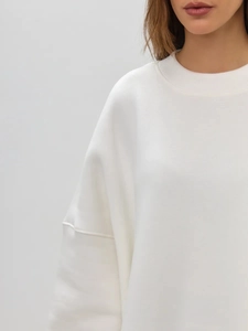 Detail of white crew neck sweatshirt showing premium knit fabric and dropped shoulder seam