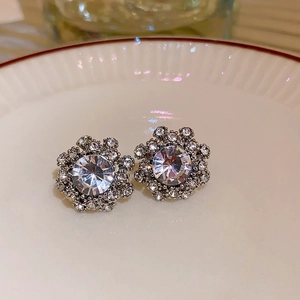 Macro shot of elegant flower-shaped stud earrings with sparkling crystals and vintage metal base