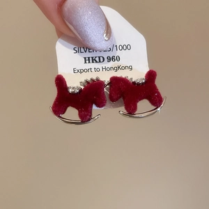 Macro detail of red flocked rocking horse earrings with 925 silver base and sparkling zircon
