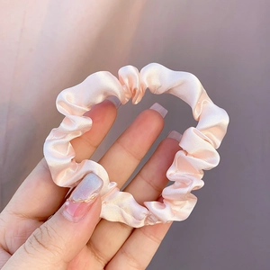Chouchou en satin rose poudré avec texture en soie plissée pour une coiffure sans traces
