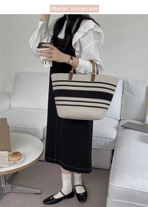 Detail of woven tote bag with black stripes and vintage bamboo handles for daily use