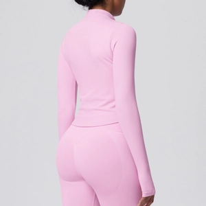 Macro detail of seamless pink rib-knit texture on fitted zipper yoga jacket and high-waist pants