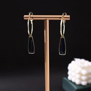 Vue macro détaillée de boucles d'oreilles géométriques en émail noir sur support doré