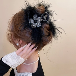 Détail d'une pince à cheveux élégante avec plumes noires et strass brillants sur cheveux