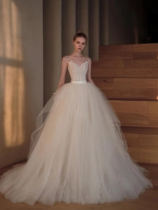 Detail of ivory lace embroidery and delicate bow on a slim-fit tulle bridal gown