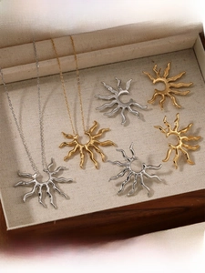 Detailed view of sunburst necklace and earrings set in gold and silver finish