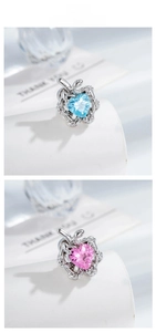 Macro detail of heart-cut zircon studs with silver snake wrap design in blue and pink
